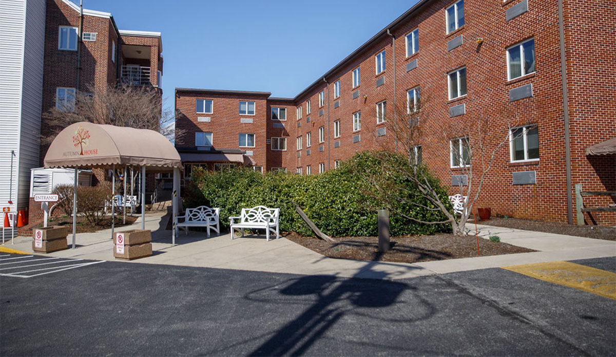 A building exterior featuring a patio with several chairs arranged for outdoor seating.